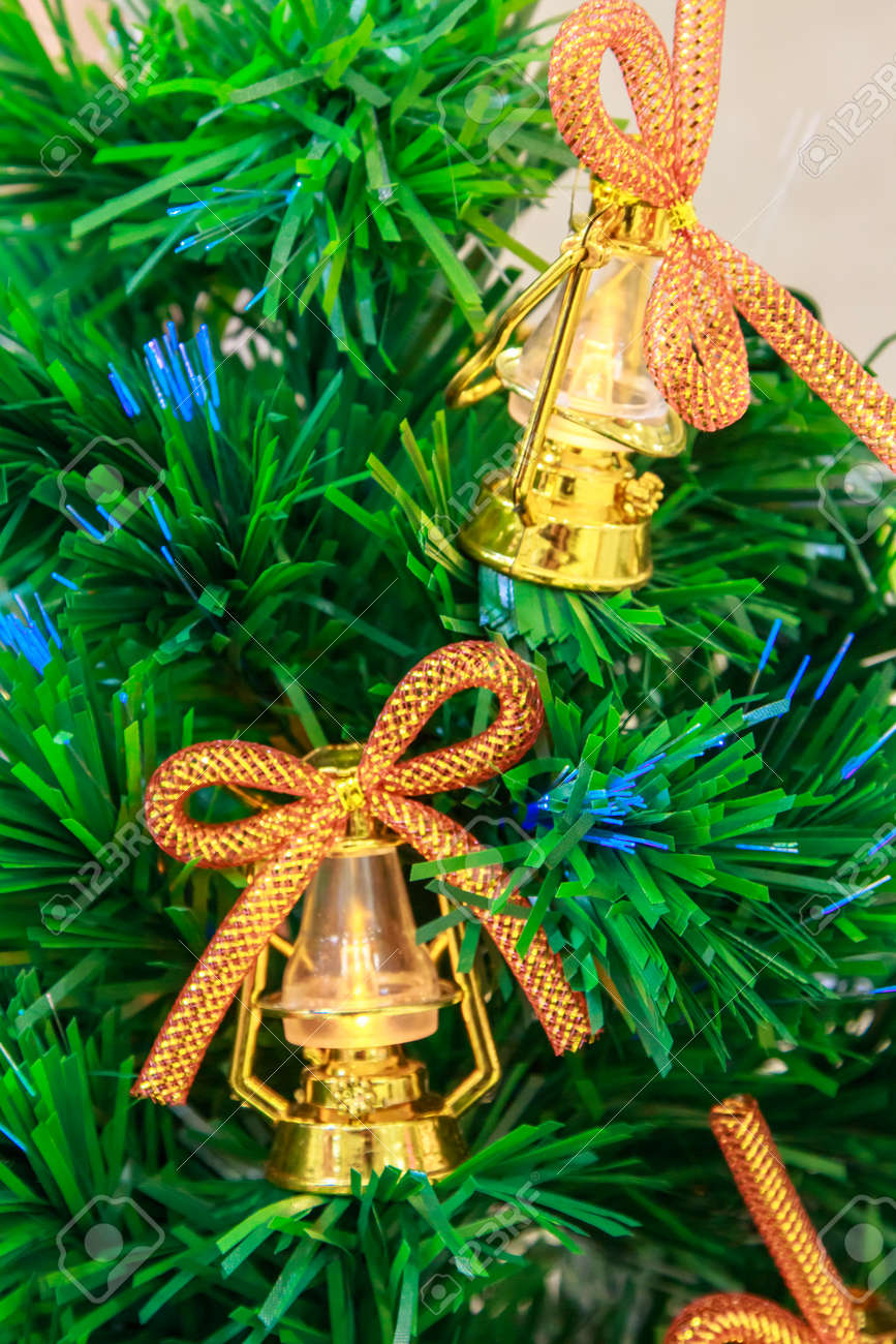 Golden Christmas Tree Bells And Lanterns With Bows On An Artificial Stock Photo Golden Christmas Tree Bells And Lanterns With Bows On An Artificial Stock Photo