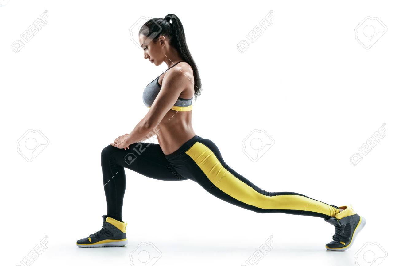 Fitness woman doing stretching workout. Full length shot of young woman on white background. Stretching and motivation - 78518366 Fitness woman doing stretching workout. Full length shot of young woman on white background. Stretching and motivation - 78518366