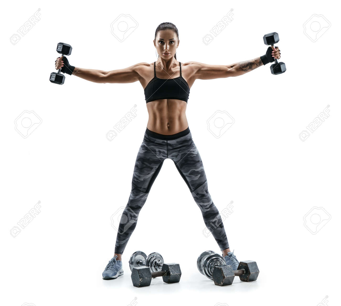 Fitness model exercising with dumbbells in both hands. Photo of muscular woman isolated on white background. Strength and motivation. - 78518372 Fitness model exercising with dumbbells in both hands. Photo of muscular woman isolated on white background. Strength and motivation. - 78518372