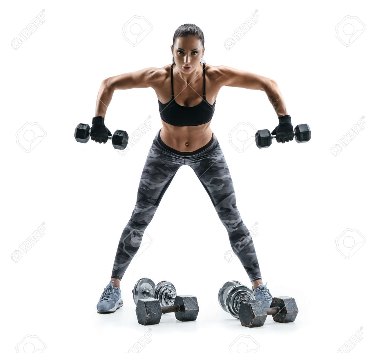 Strong woman exercising with dumbbells for arms. Photo of woman working out with heavy dumbbells on white background. Strength and motivation. - 78518374 Strong woman exercising with dumbbells for arms. Photo of woman working out with heavy dumbbells on white background. Strength and motivation. - 78518374