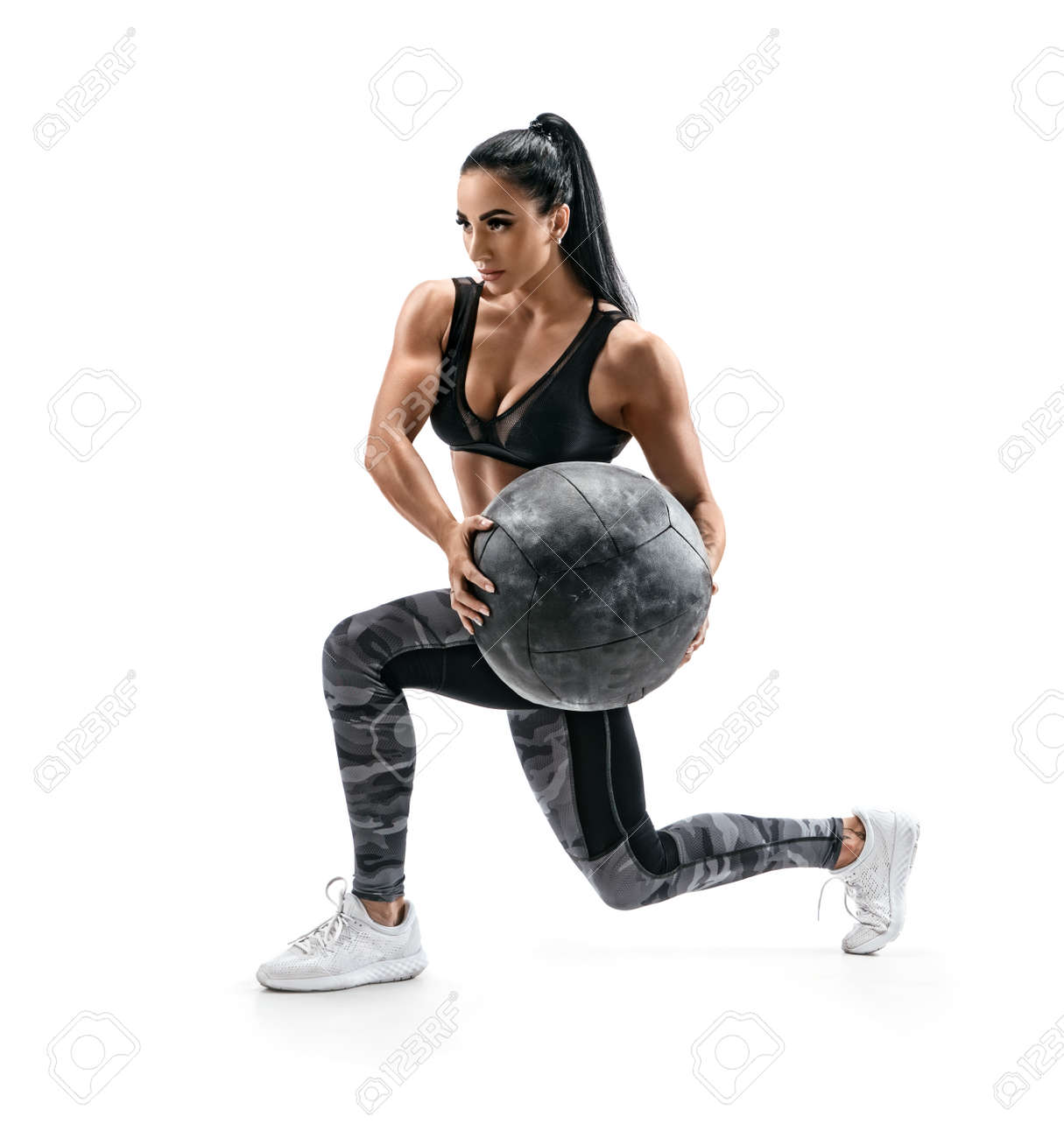 Muscular woman doing lunge twist exercise with med ball. Photo of woman with great physique isolated on white background. Strength and motivation - 105002510 Muscular woman doing lunge twist exercise with med ball. Photo of woman with great physique isolated on white background. Strength and motivation - 105002510