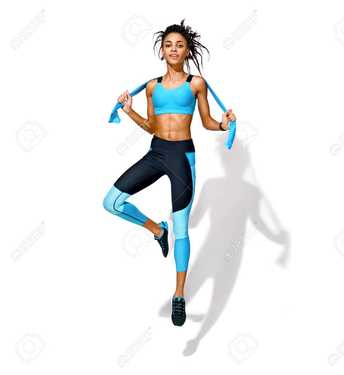 Deportiva Con Banda Elástica De Resistencia En Movimiento. Foto De Niña Afroamericana En Ropa Deportiva De Moda Sobre Fondo Blanco. Movimiento Dinámico. Longitud Deporte Y Estilo Vida Saludable Fotos,
