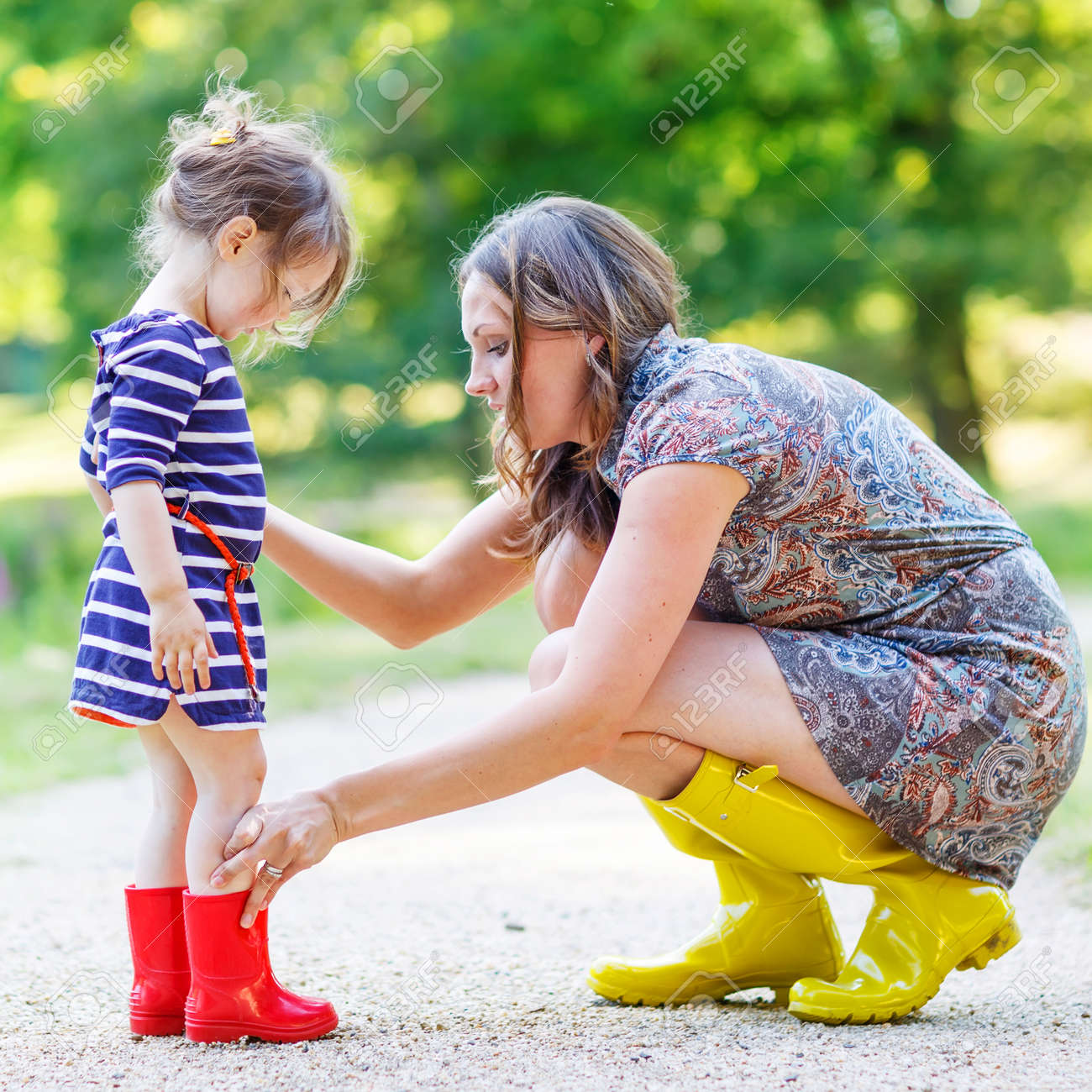 若い母親と楽しんでゴム長靴で愛らしい子少女 一緒に家族に見える 晴れた暖かい日に夏の公園で の写真素材 画像素材 Image