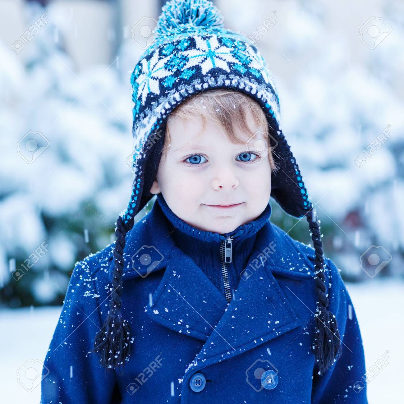 雪と冬の服でかわいい幼児男の子の肖像画 子供の楽しむと寒い日に屋外 雪の結晶をキャッチします の写真素材 画像素材 Image