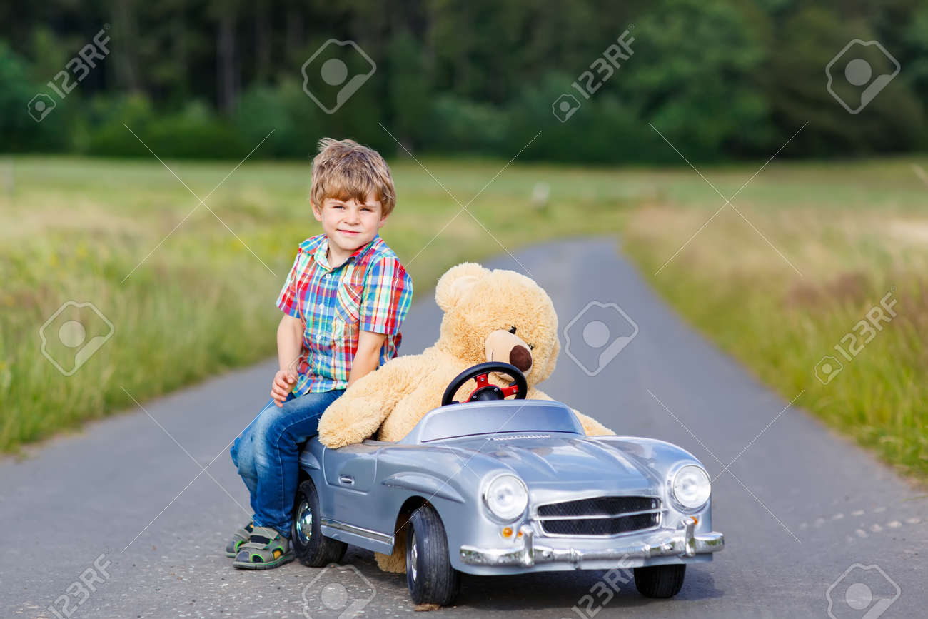 就学前の小さな子供男の子大きなおもちゃの車を運転 彼のぬいぐるみのクマを屋外に楽しんで 自然の風景の中の暖かい夏の日を楽しむ子供 の写真素材 画像素材 Image