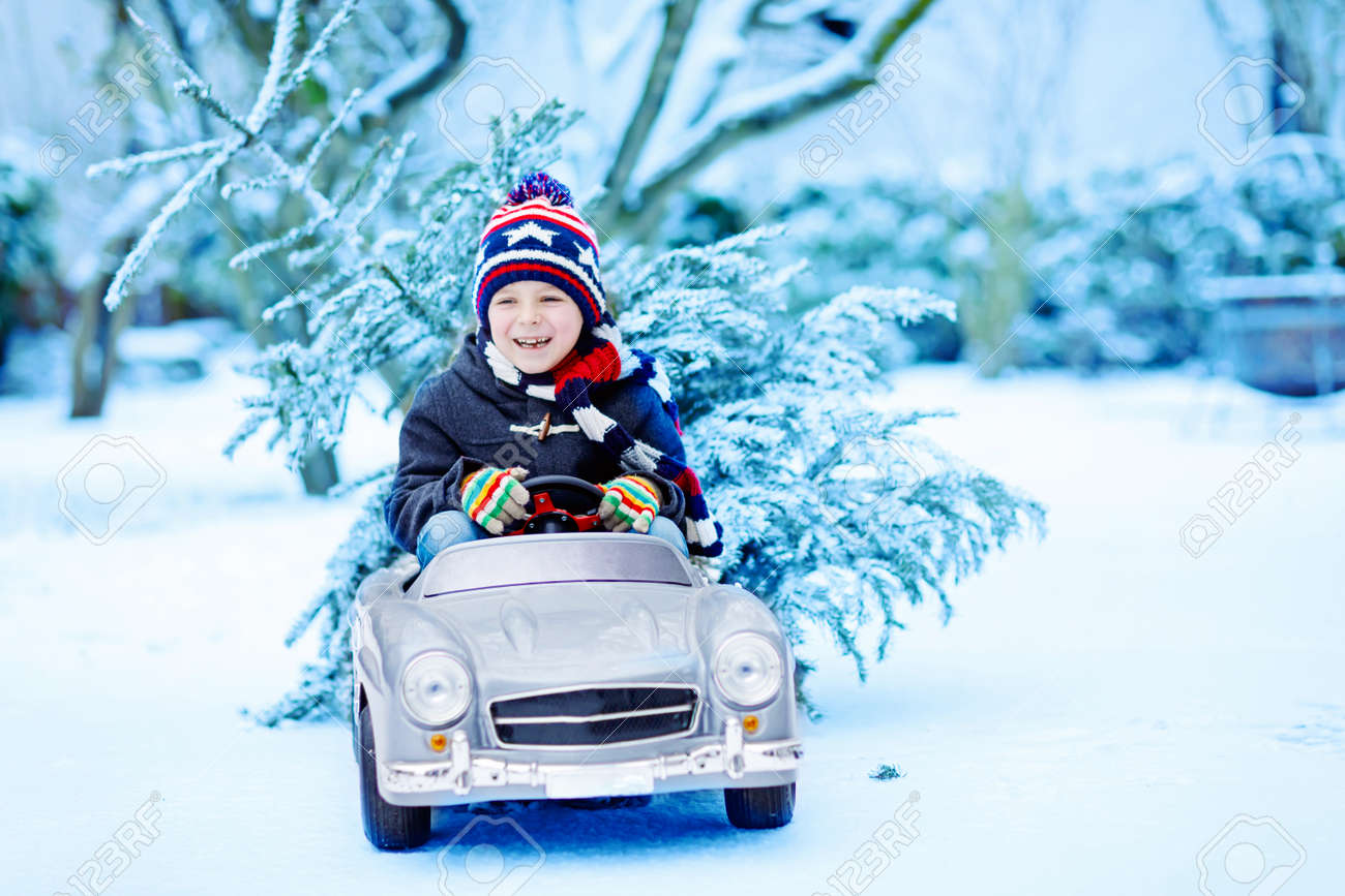 面白い笑顔子供男の子のクリスマス ツリーでおもちゃの車を運転します の写真素材 画像素材 Image