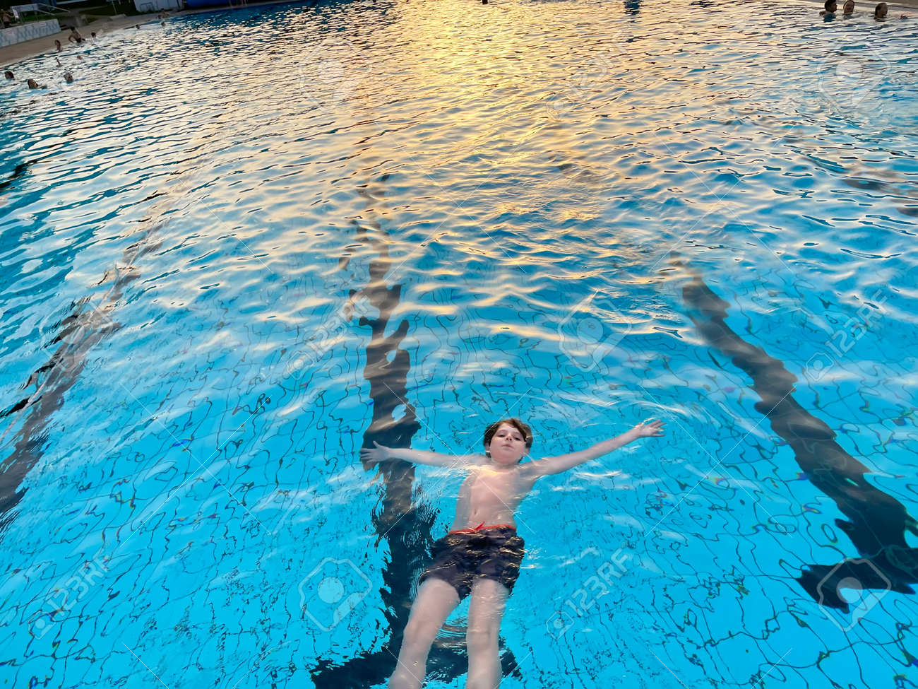 js プール  暖かい夏の日に屋外プールで水しぶきをあげる小学生の男の子。市の公共プールで晴天を楽しんで幸せな健康的なプレティーンの子供。子供たちは水で屋外で活動します。の写真素材・画像素材  Image 170587383