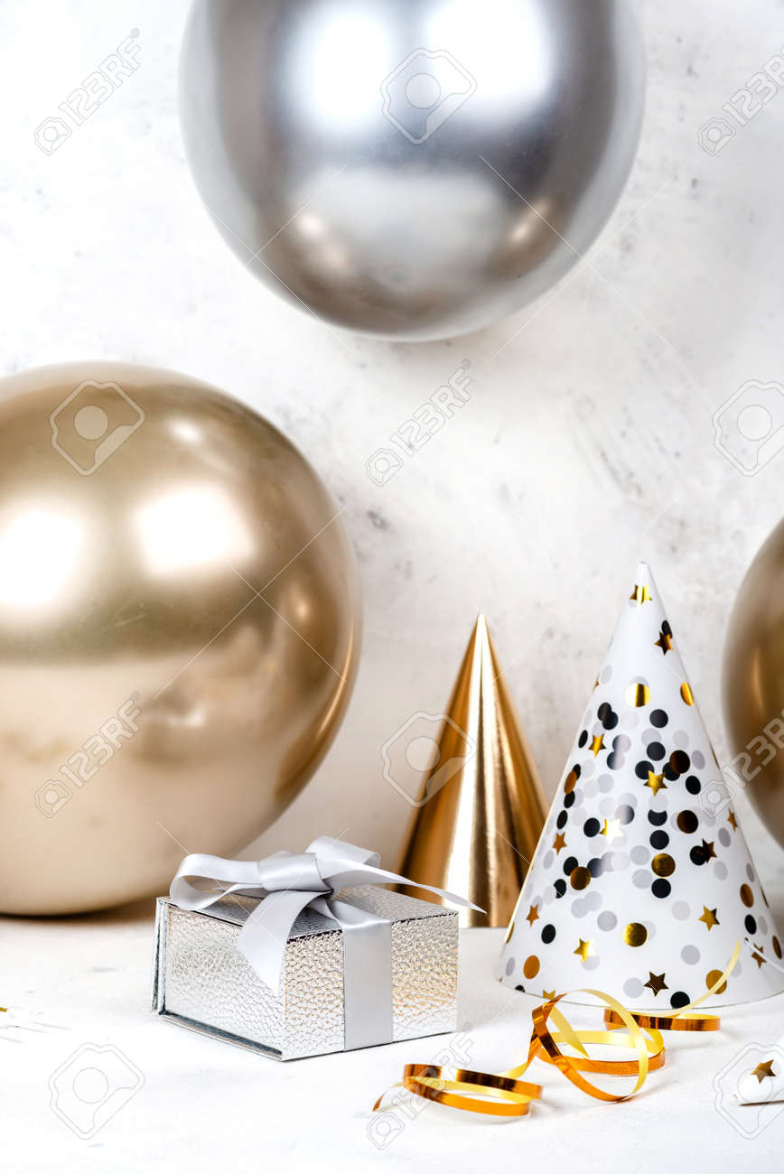Birthday festive concept Silver gifts box and golden silver balloons with party hats - 167848328 Birthday festive concept Silver gifts box and golden silver balloons with party hats - 167848328
