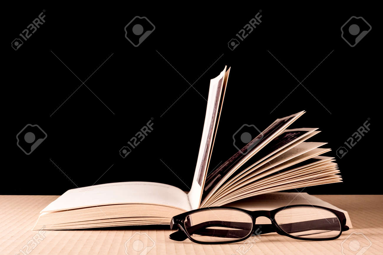 Book and eyeglasses on wooden table, Black background - 72432966 Book and eyeglasses on wooden table, Black background - 72432966