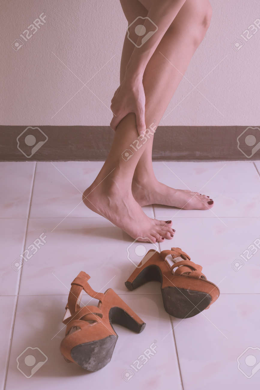女性は高いヒールの靴を着用した後の疲れた足をマッサージします の写真素材 画像素材 Image