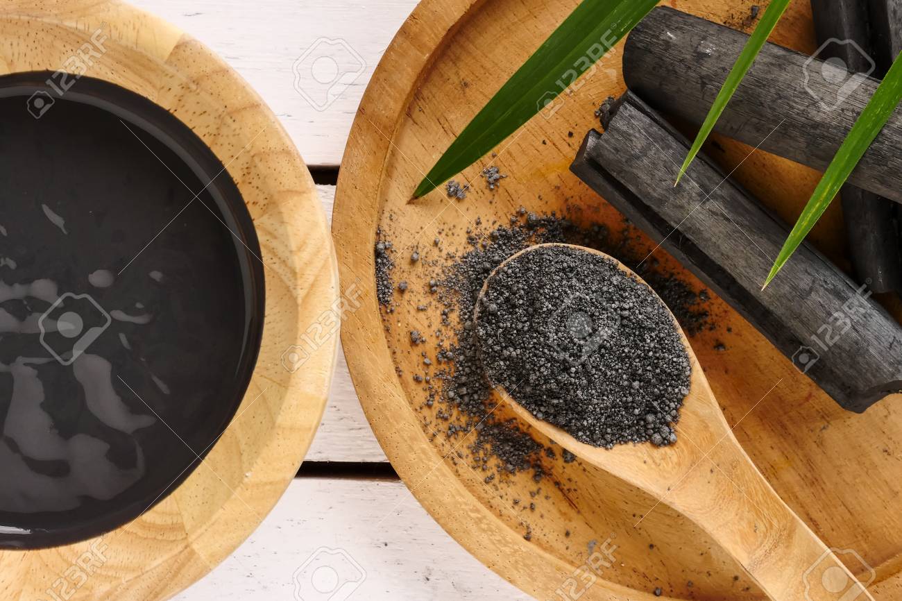 Facial mask and scrub by activated charcoal powder on wooden table - 105102522 Facial mask and scrub by activated charcoal powder on wooden table - 105102522