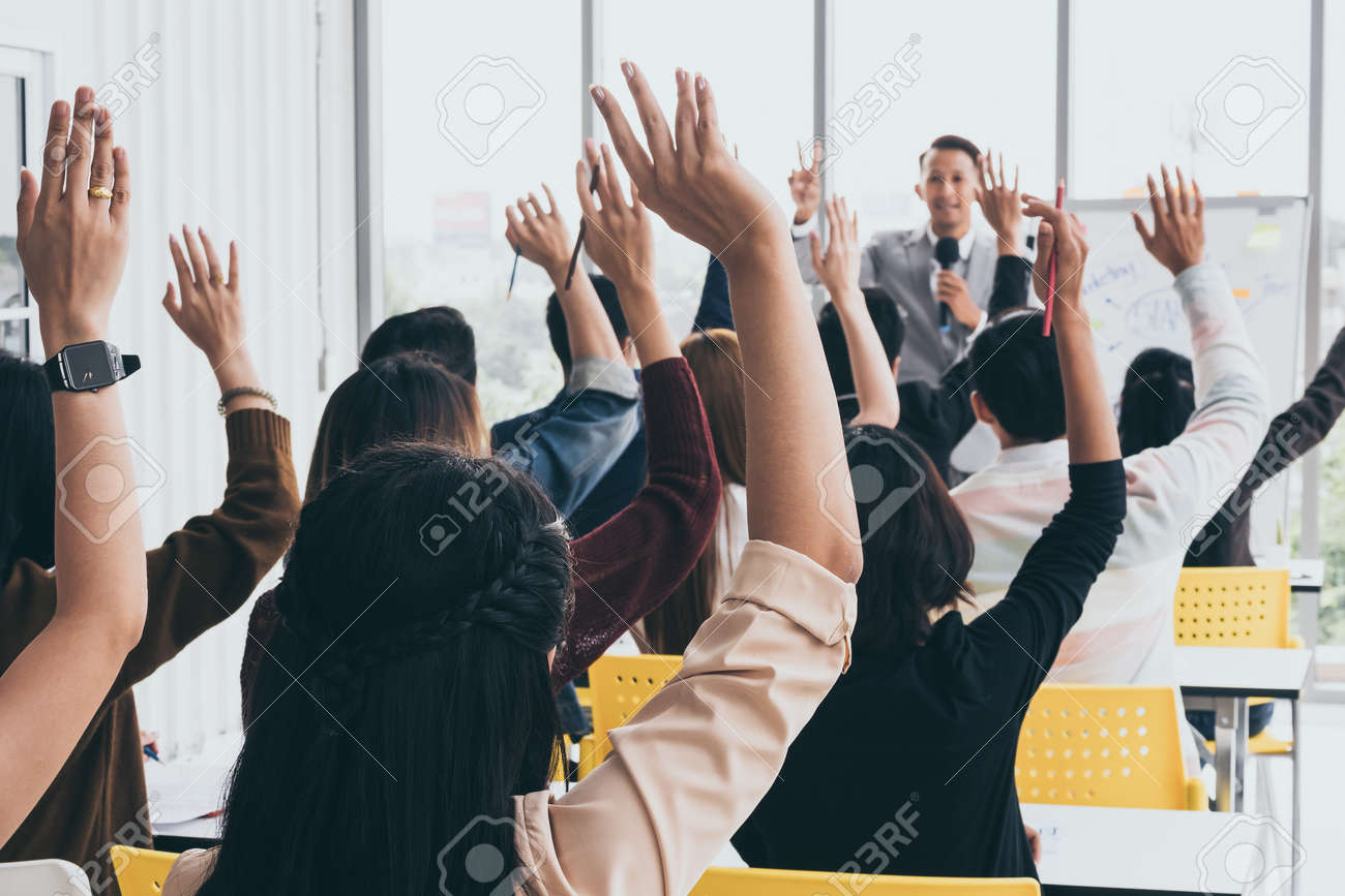 Audience raising hands up while businessman is speaking in training at the office. - 109206270 Audience raising hands up while businessman is speaking in training at the office. - 109206270