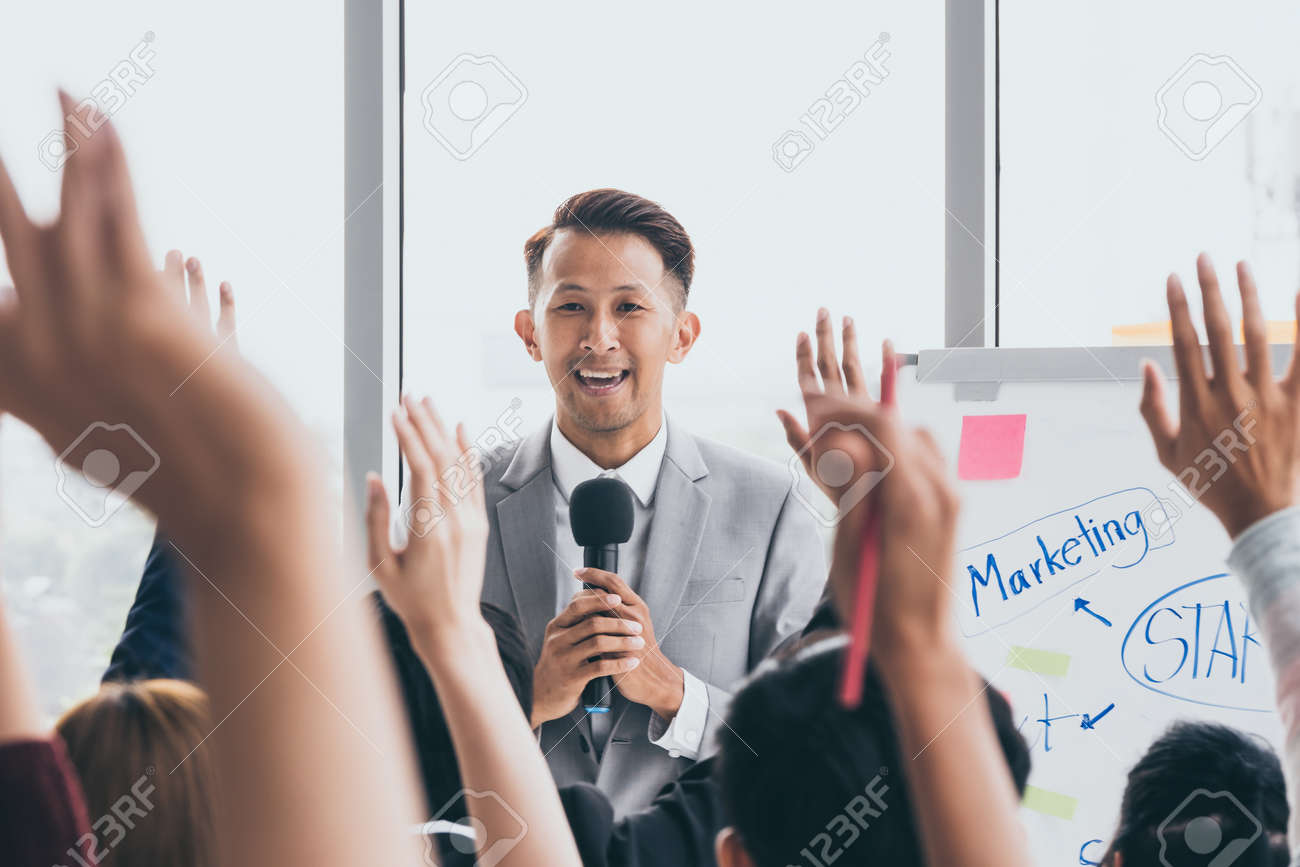 Audience raising hands up while businessman is speaking in training at the office. - 109816548 Audience raising hands up while businessman is speaking in training at the office. - 109816548