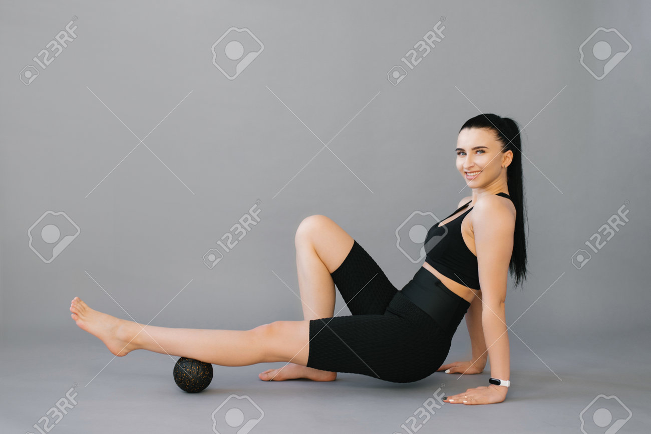 アスレチックスレンダー白人女性は、マッサージボールですねにセルフマッサージをします。自己隔離マッサージの写真素材・画像素材 Image  191165616