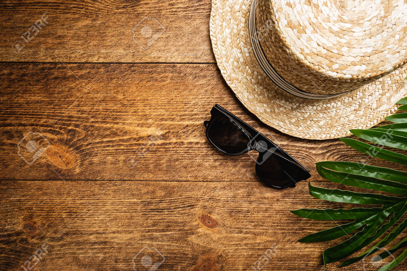 Straw beach hat and sun glasses top view on wooden background, summer flat lay - 153184967 Straw beach hat and sun glasses top view on wooden background, summer flat lay - 153184967