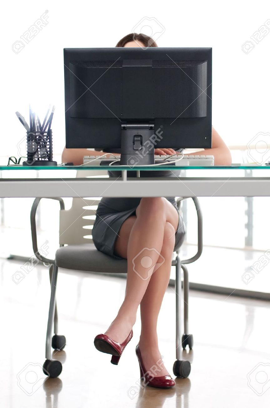 girl sitting at his work place behind a computer screen stock photo