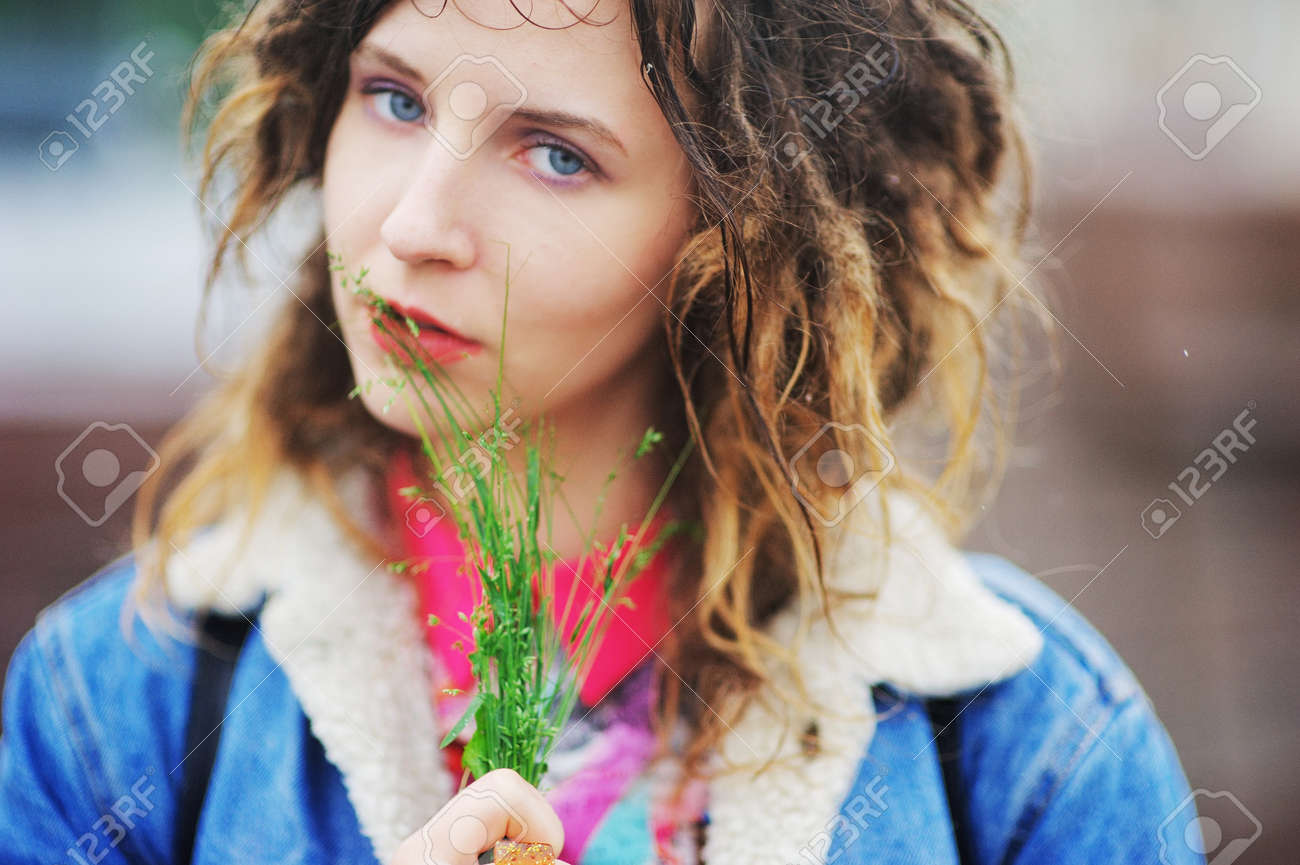 Young Cute Girl With Dreadlocks With A Bunch Of Grass On The