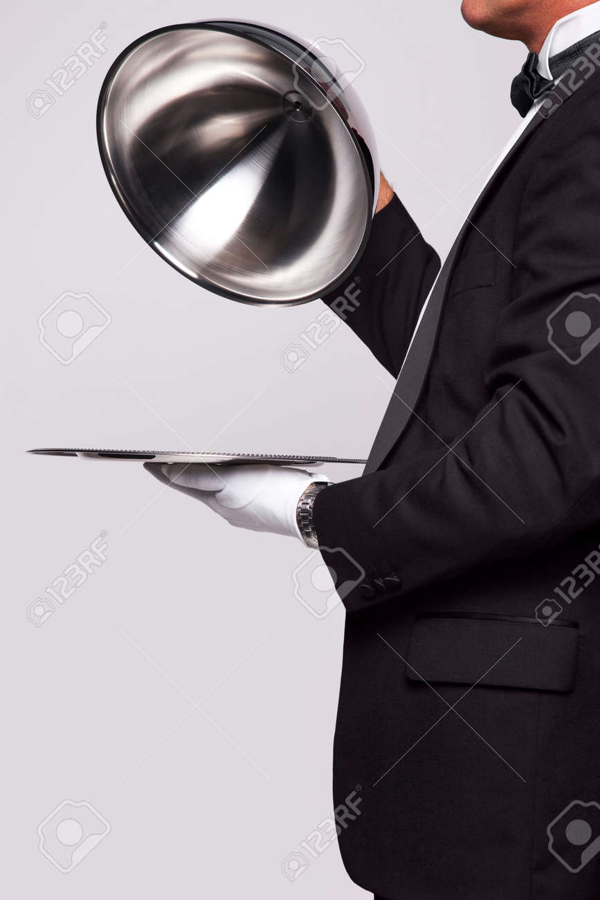 Butler lifting the cloche from a silver serving tray, insert your own object onto the tray. - 6444163 Butler lifting the cloche from a silver serving tray, insert your own object onto the tray. - 6444163