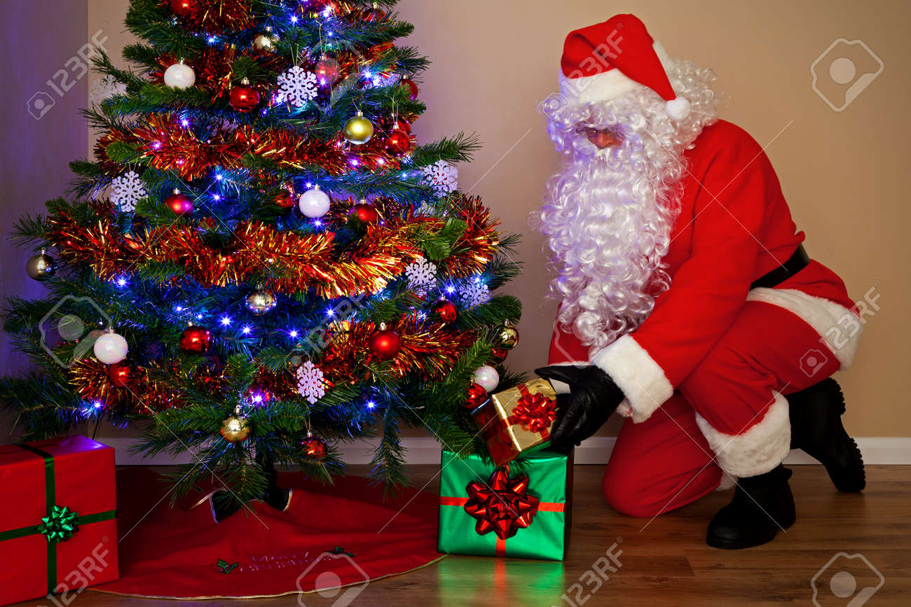Santas Claus Delivering Presents And Putting The Gifts Under Christmas Tree His Other Names