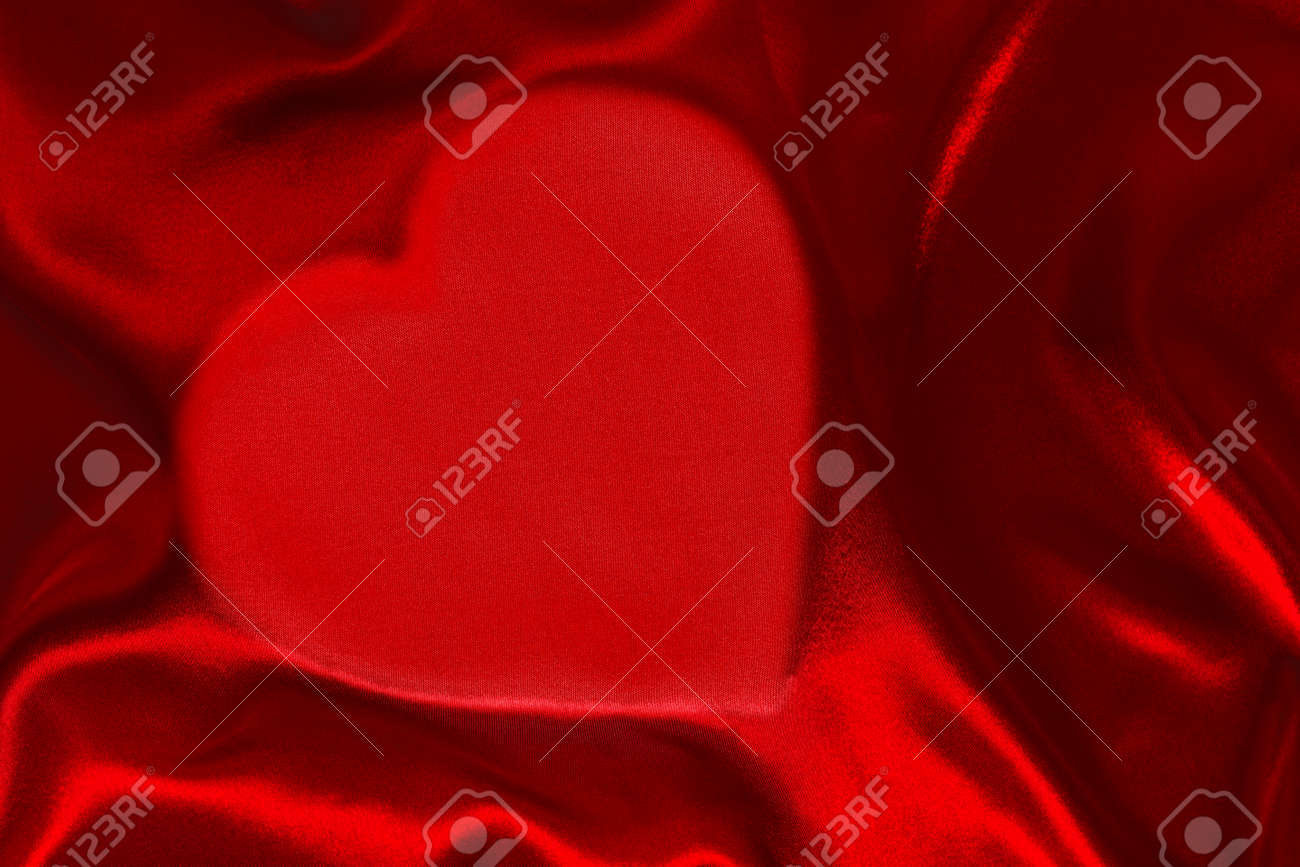 a red silk sheet with heart shape underneath stock photo picture red silk sheet