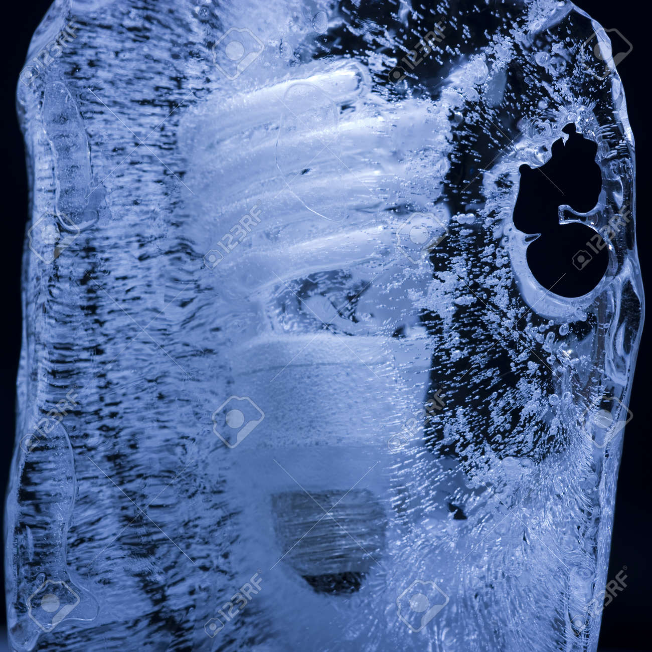 energy saving light bulb frozen in a block of ice stock photo