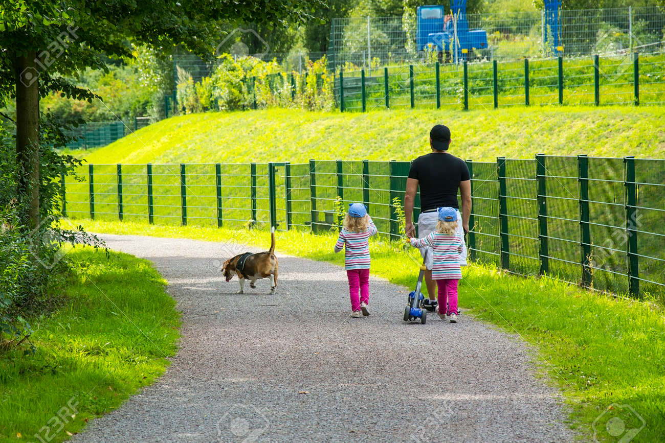 子供の双子と犬と一緒に散歩中の父親 の写真素材 画像素材 Image