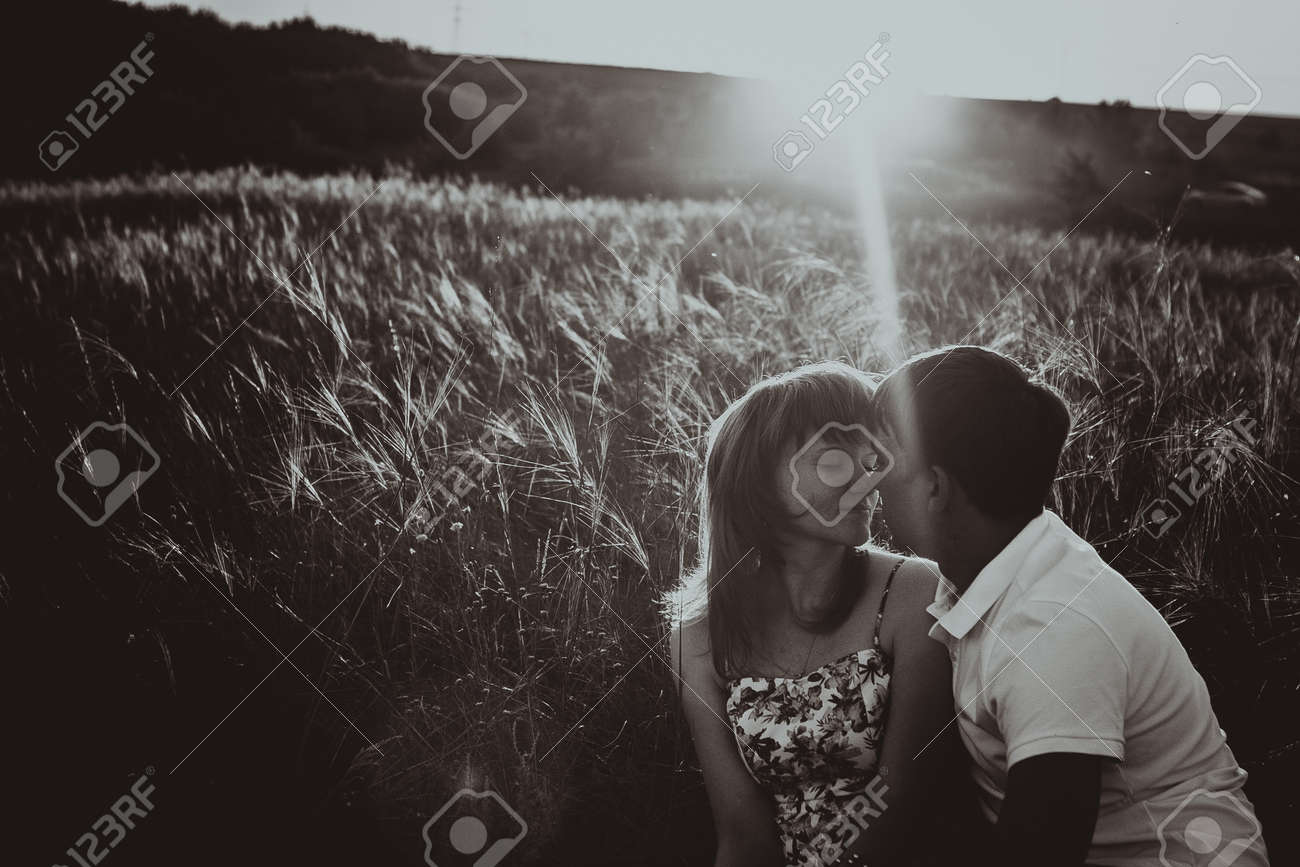 Romantic black white photo couple standing and kissing on background