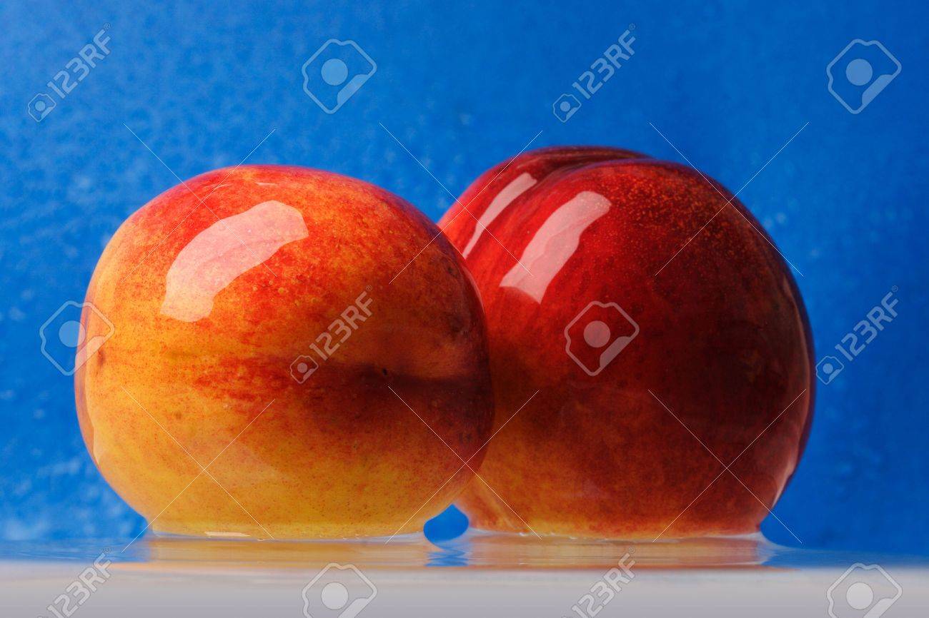 Two Wet Peaches Over Blue Background Stock Photo, Picture and Royalty Free  Image. Image 2087421.