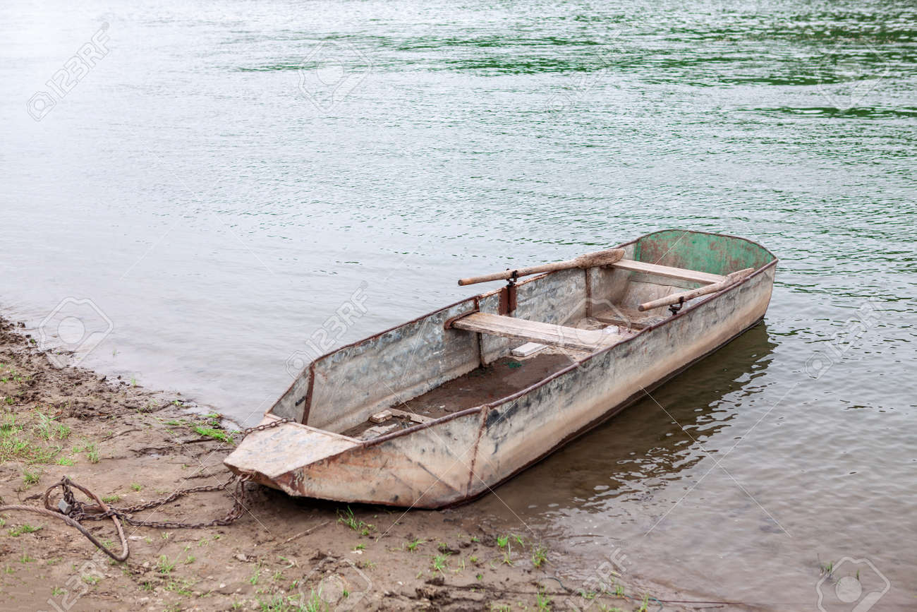 Moored rusty metal boat with oars . Fishing village - 169406724 Moored rusty metal boat with oars . Fishing village - 169406724