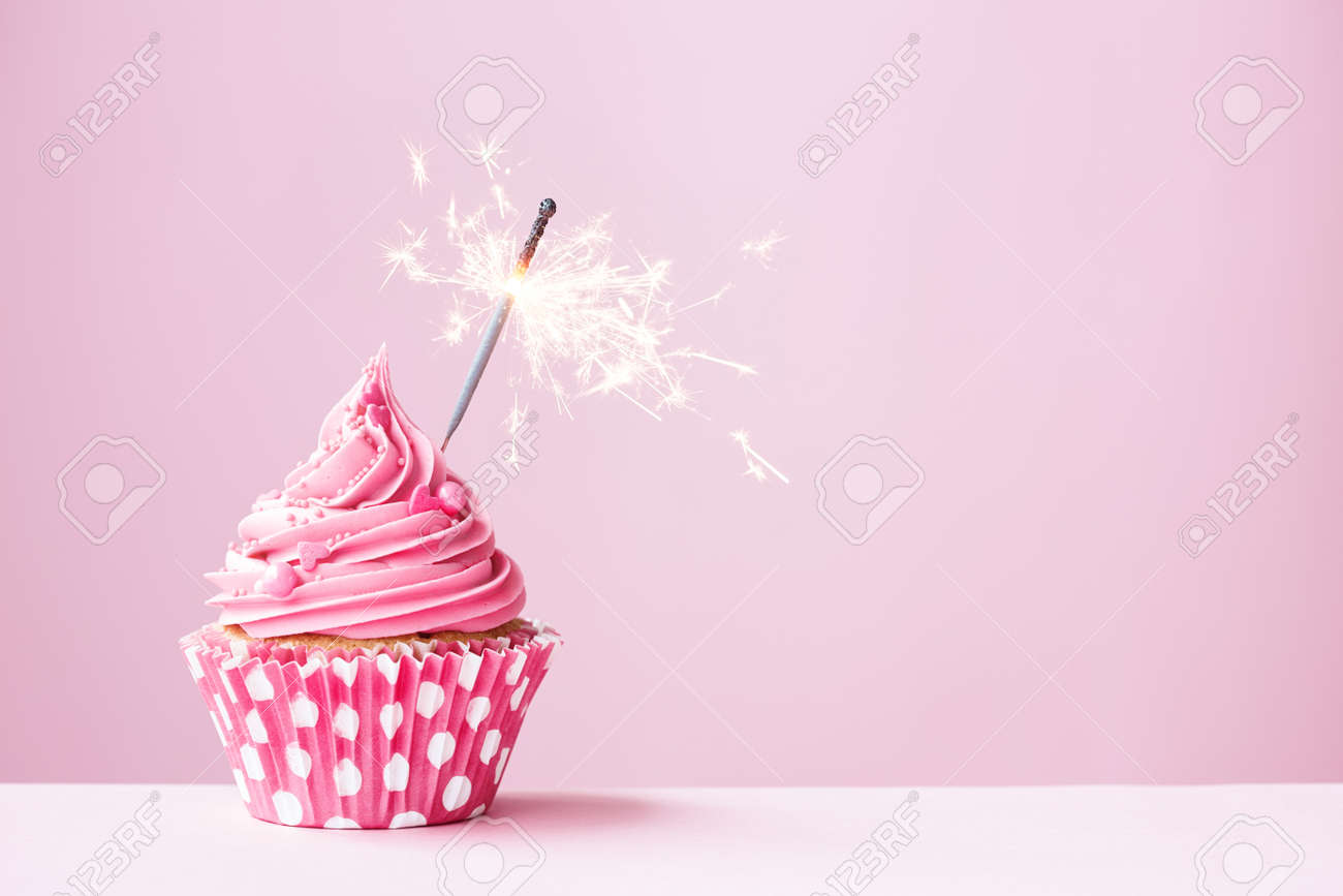pink cupcake decorated with a sparkler stock photo picture and birthday pink