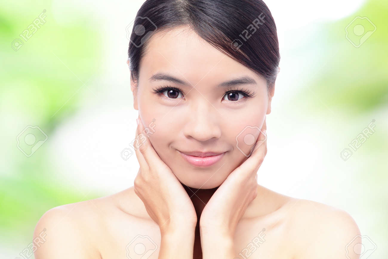 クローズ アップ美容女性の顔と手のタッチの緑の背景で彼女の顔 モデルは美しいアジアの少女 の写真素材 画像素材 Image