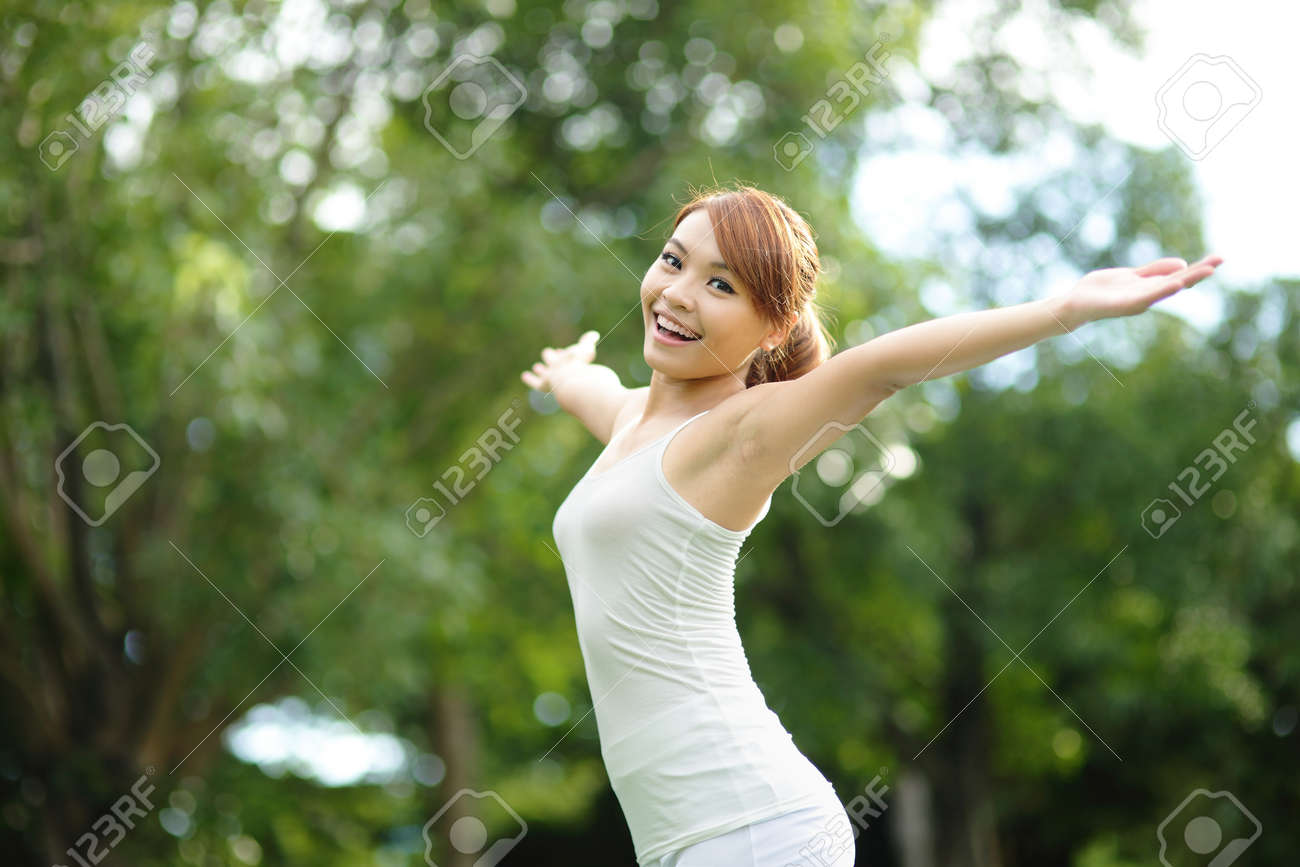 応援　女性 屈託のない無料応援団の女性は公園で。少女の幸せな笑顔を彼女の腕を上げます。アジアの美しさの写真素材・画像素材 Image 34555565
