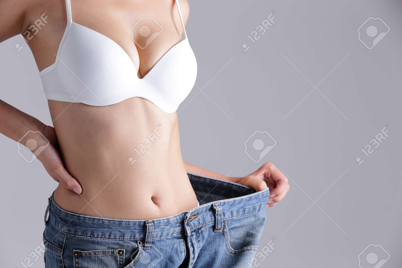 woman shows weight loss by wearing old jeans, asian beauty - 40856636 woman shows weight loss by wearing old jeans, asian beauty - 40856636