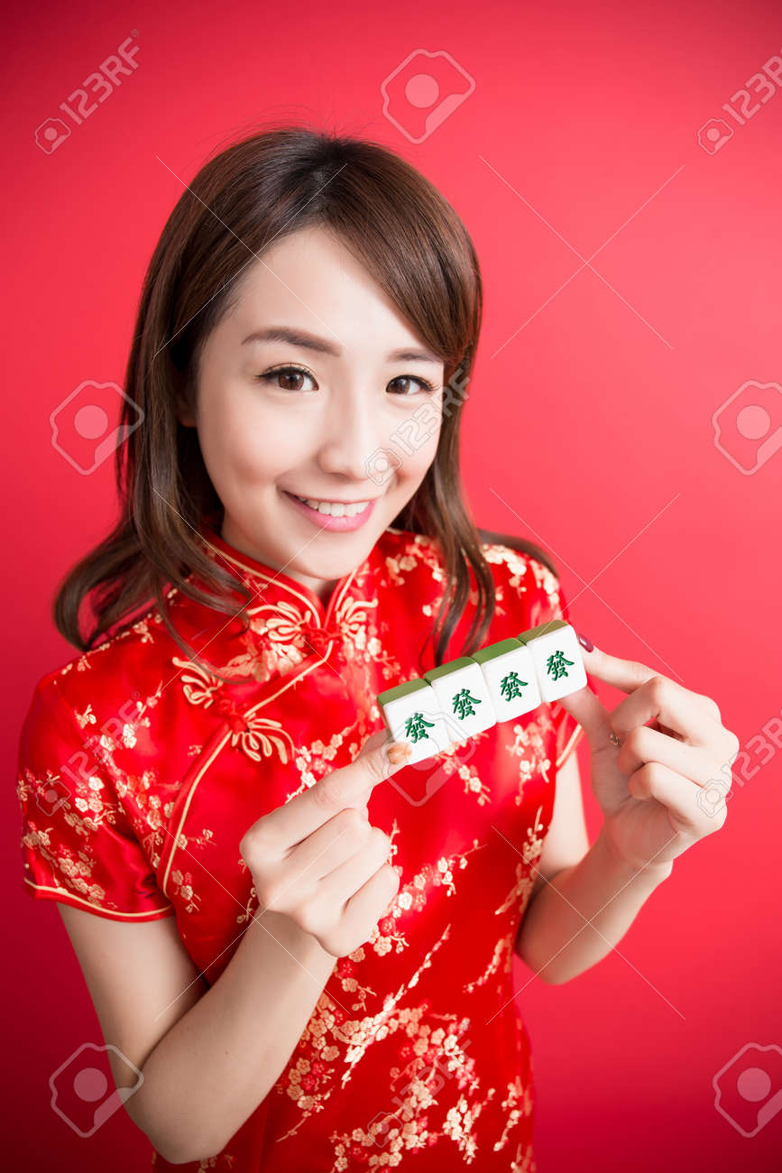 中国語で手の女の子の裕福なテキストと美容女性のチャイナ ドレスを着用し 中国の旧正月 リッチで麻雀を表示 の写真素材 画像素材 Image