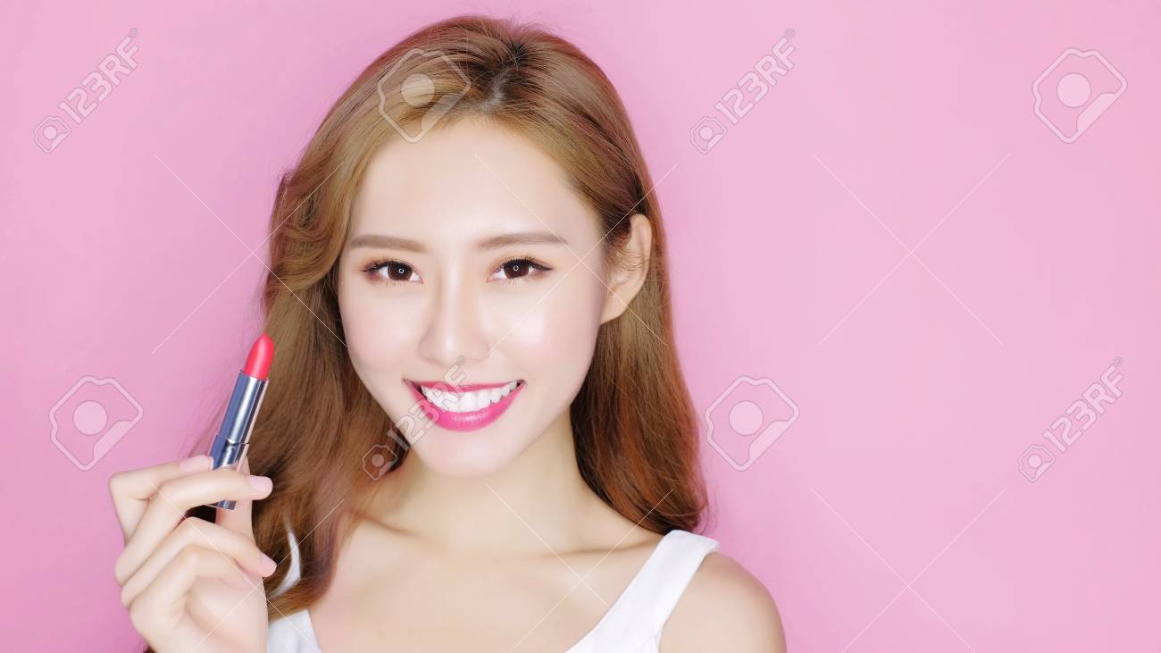 ピンクの背景に口紅であなたに笑顔の美容メイク女性 の写真素材 画像素材 Image