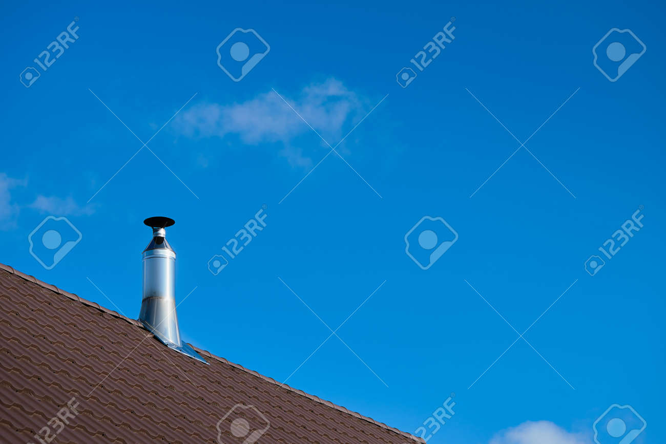 Modern style chimney from oven or fireplace stacked stainless steel on tiled roof made according to fire safety requirements, and to avoid condensation when reaching dew point in flue gases. - 146538106 Modern style chimney from oven or fireplace stacked stainless steel on tiled roof made according to fire safety requirements, and to avoid condensation when reaching dew point in flue gases. - 146538106