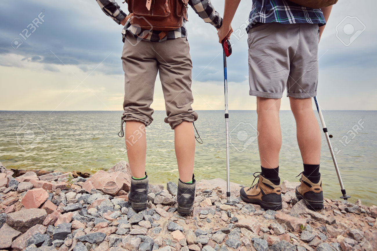 Travelers couple look at the mountain lake. Travel and active life concept with team. - 170687717 Travelers couple look at the mountain lake. Travel and active life concept with team. - 170687717