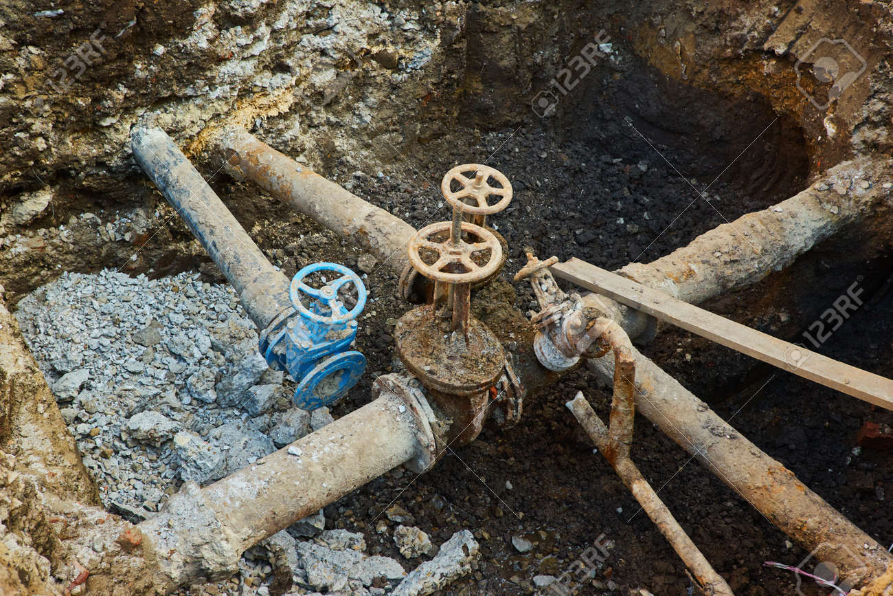 Old city water main taps, a hole dug to repair or replace water supply units - 169020789 Old city water main taps, a hole dug to repair or replace water supply units - 169020789
