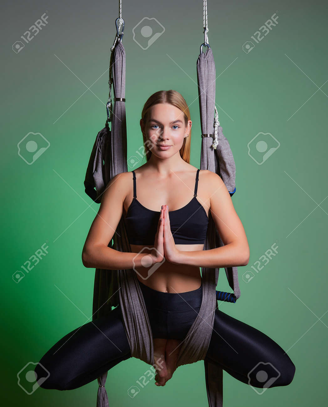 portrait young women making antigravity yoga exercises. Aerial aero fly fitness trainer workout. lotus. meditates. harmony and serenity concept - 169021157 portrait young women making antigravity yoga exercises. Aerial aero fly fitness trainer workout. lotus. meditates. harmony and serenity concept - 169021157
