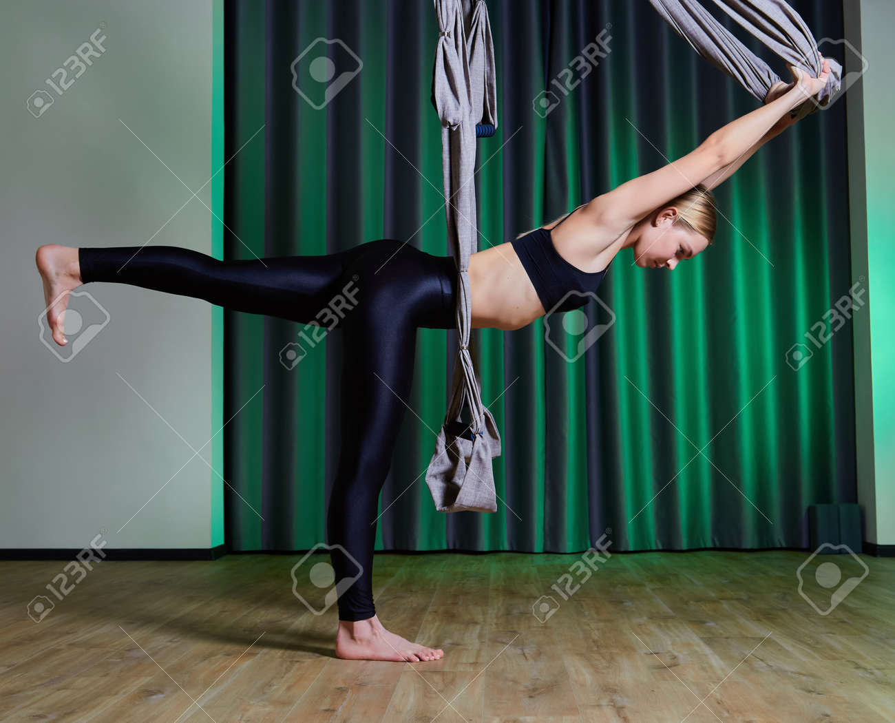Attractive peaceful young woman doing aerial yoga in studio - 169021165 Attractive peaceful young woman doing aerial yoga in studio - 169021165