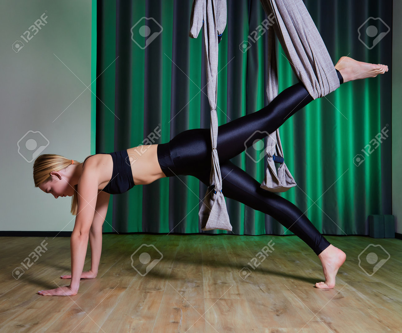 Attractive peaceful young woman doing aerial yoga in studio - 169021180 Attractive peaceful young woman doing aerial yoga in studio - 169021180