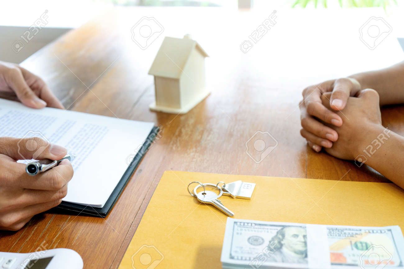 Sale representative or insurance broker offer house purchase contract to buy a house or apartment and give home key chain to customer - 169322434 Sale representative or insurance broker offer house purchase contract to buy a house or apartment and give home key chain to customer - 169322434