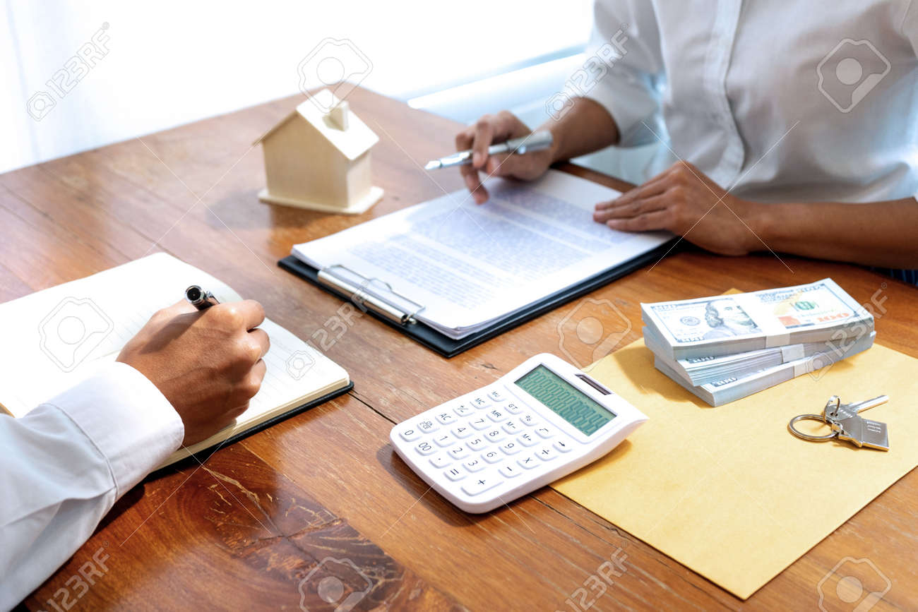 Sale representative or insurance broker offer house purchase contract to buy a house or apartment and give home key chain to customer - 169230089 Sale representative or insurance broker offer house purchase contract to buy a house or apartment and give home key chain to customer - 169230089
