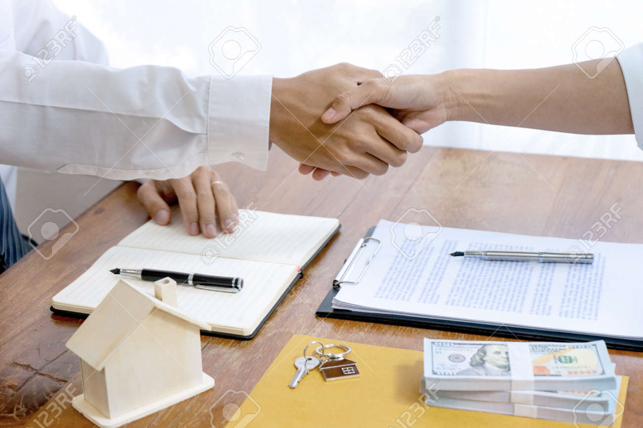 Sale representative or insurance broker handshake with customer after house purchase contract buy a house or apartment - 169230091 Sale representative or insurance broker handshake with customer after house purchase contract buy a house or apartment - 169230091
