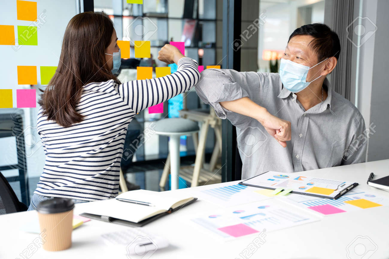 Businessman wearing a mask say hi to another no handshake but use elbow bump not to risk the new in the concept new normal. - 169229445 Businessman wearing a mask say hi to another no handshake but use elbow bump not to risk the new in the concept new normal. - 169229445