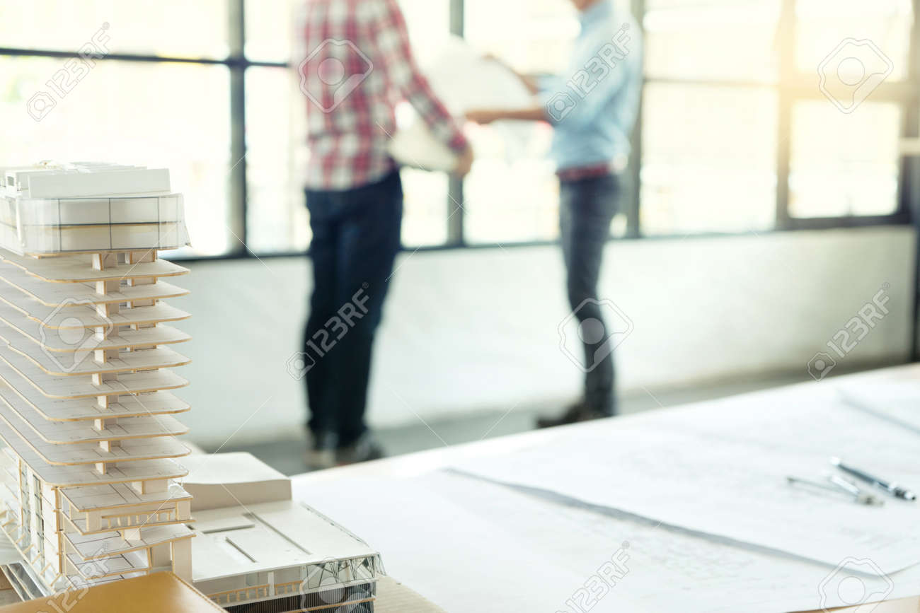 Focus on the building model houses architect or engineer standing near the window talking about business architectural project - 169229547 Focus on the building model houses architect or engineer standing near the window talking about business architectural project - 169229547
