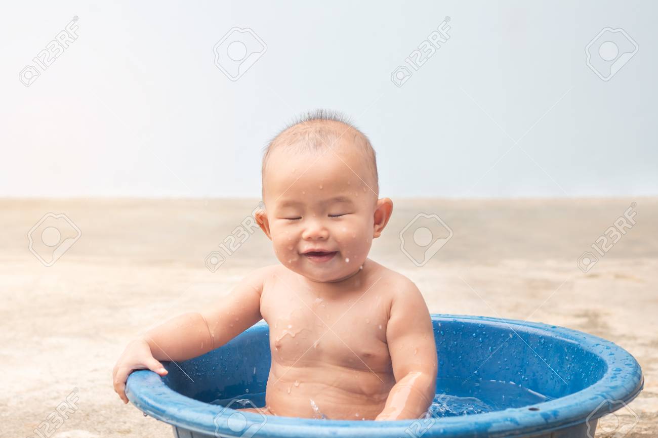 子供の学習 シャワーの間にプラスチックの洗面器にボールをプレーかわいい新しい生まれた赤ちゃん の写真素材 画像素材 Image