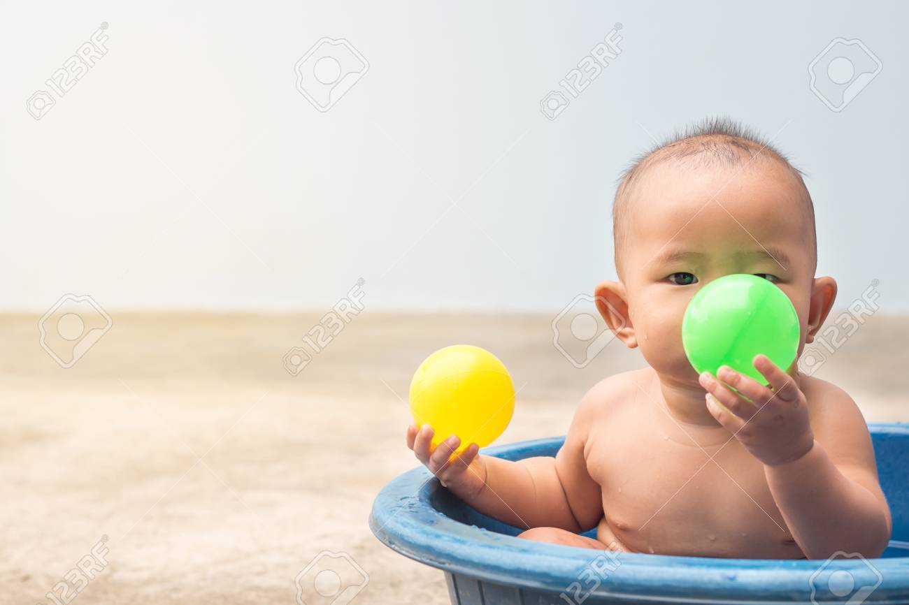 子供の学習 シャワーの間にプラスチックの洗面器にボールをプレーかわいい新しい生まれた赤ちゃん の写真素材 画像素材 Image