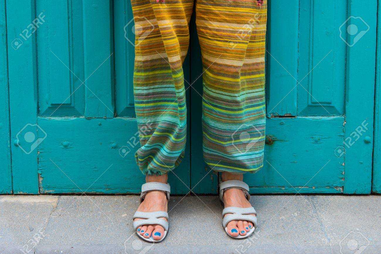 Pies De Una Mujer En Sandalias Con Unas Azules Pantalones Hippie