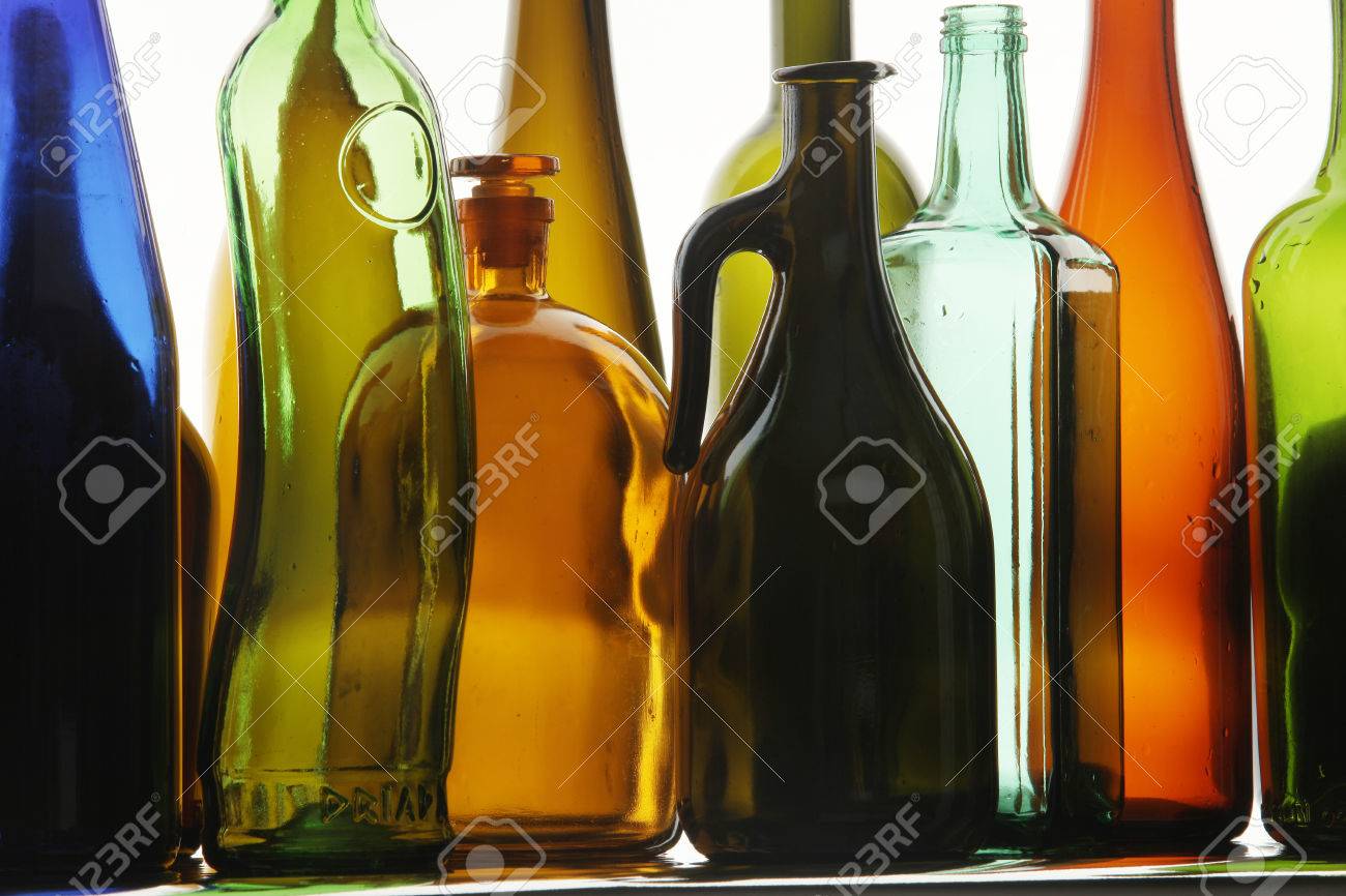 close up clean transparent colored glass bottles of different shapes on the mirror surface in - Colored Glass close up clean transparent colored glass bottles of different shapes on the mirror surface in - Colored Glass